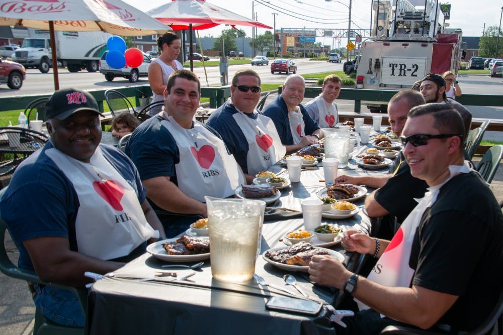 Members of the Muncie Fire Department (right) and Muncie Police Department (left) smile before beginning their fifth annual Battle of the Badges Sept. 18, 2018, at Texas Roadhouse in Muncie. Ten percent of every meal bought during the competition was donated to the charity of the winner's choosing. Leslie Gartrell,DN