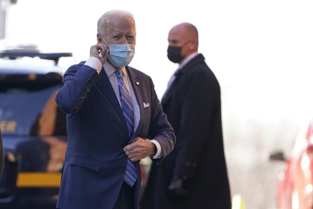 President-elect Joe Biden puts his finger on his ear as reporters shout question to him as he arrives at The Queen theater in Wilmington, Del., Monday, Dec. 7, 2020. Biden announced key appointments to his health team Monday as he hopes to build a national response to the coronavirus. (AP Photo/Susan Walsh)
