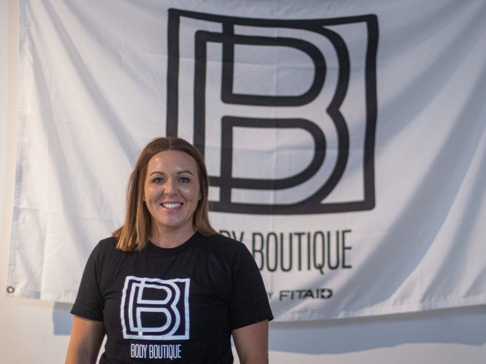 Brittney  Russell poses in front of a Body Boutique flag Sept. 10, 2020, at Body Boutique. Russell started Body Boutique out of a love for helping women reach their fitness goals. Demi Lawrence, DN