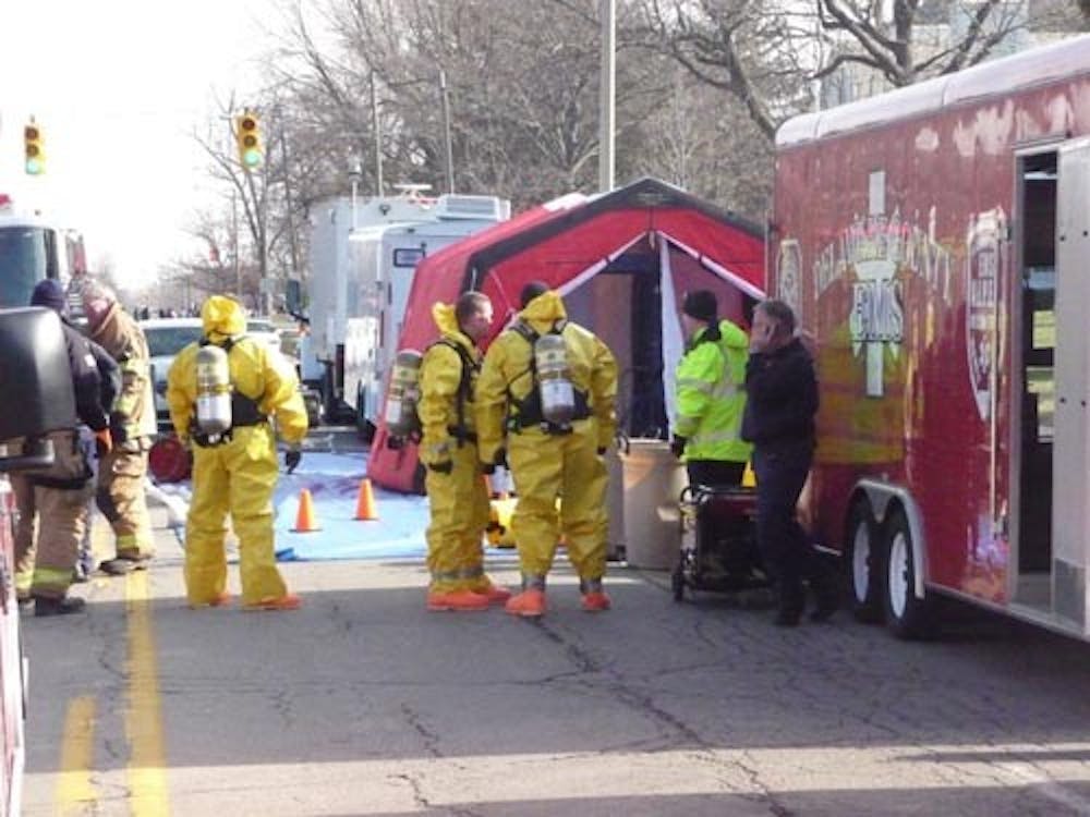 A HAZMAT crew waits outside of Burris Laboratory School on Wednesday during the disposal of chemicals that were discovered in a storage closet. The chemical, picric acid, is highly flammable in crystallized form. DN PHOTO ADAM BAUMGARTNER