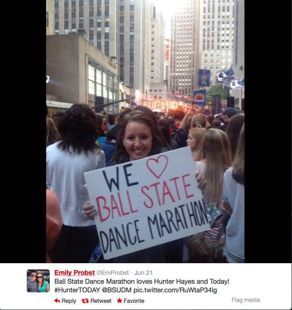 Emily Probst, Ball State University Dance Marathon president, poses with a BSUDM sign outside of 