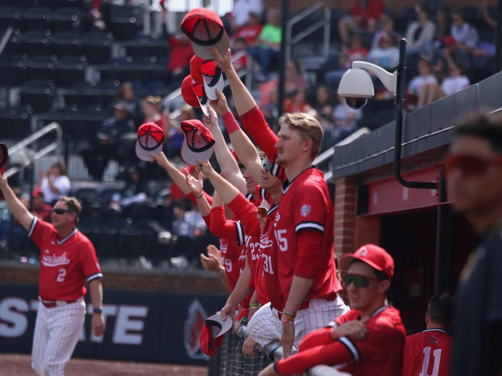 Ball State baseball lifts their hats in the dugout in the air in celebration of a catch during a game against Ohio University March 30 at First Merchants Ballpark Complex. The Cardinals won 14-7. Meghan Sawitzke, DN