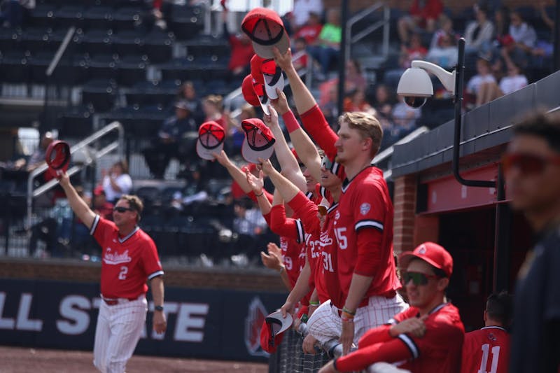 Ball State baseball lifts their hats in the dugout in the air in celebration of a catch during a game against Ohio University March 30 at First Merchants Ballpark Complex. The Cardinals won 14-7. Meghan Sawitzke, DN