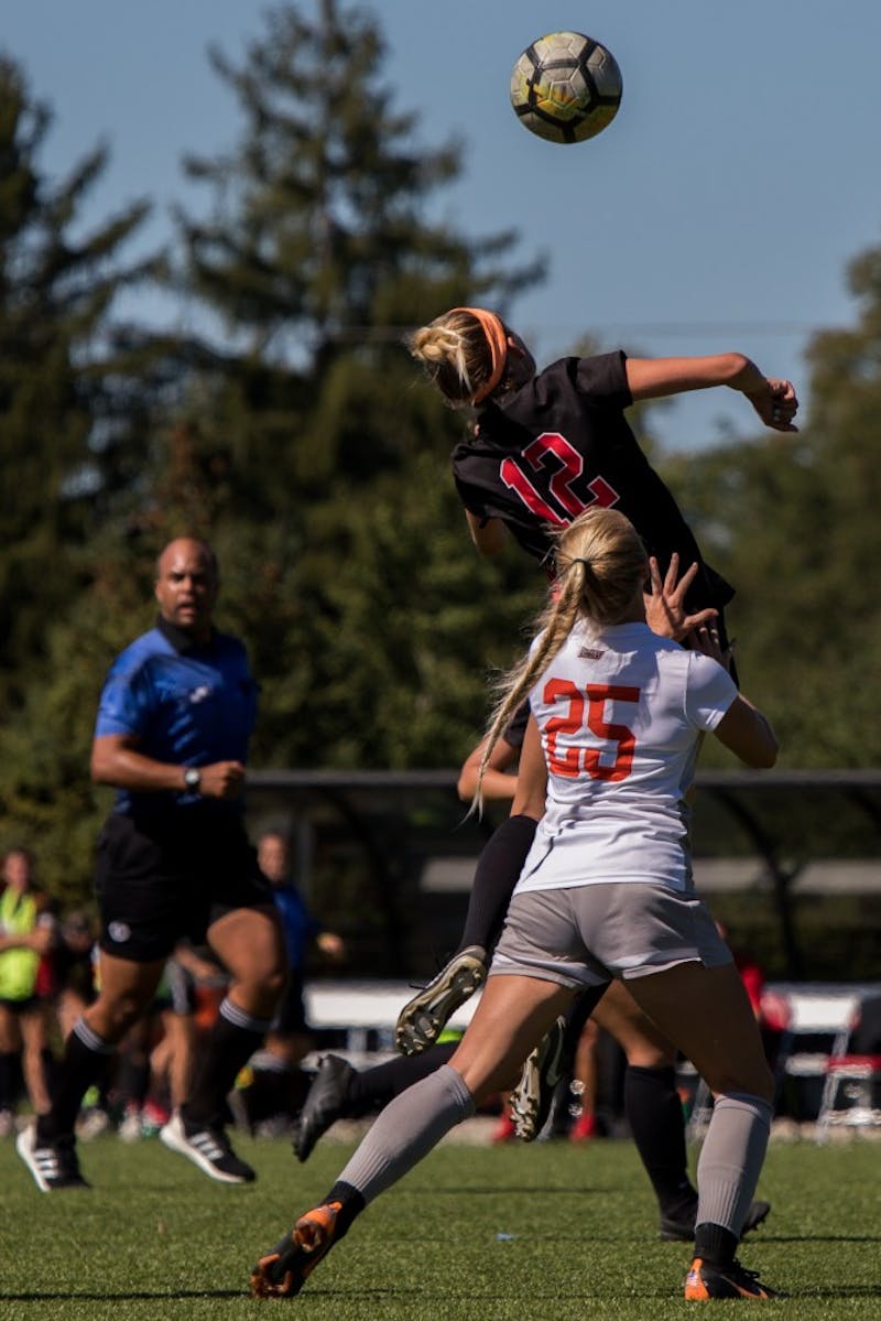 Midfielder Peighton Cook heads the ball over Bowling Green midfielder Morgan Abbitt Sept. 23, 2018, at Briner Sports Complex. The Cardinals were defeated 0 to 3. Eric Pritchett,DN