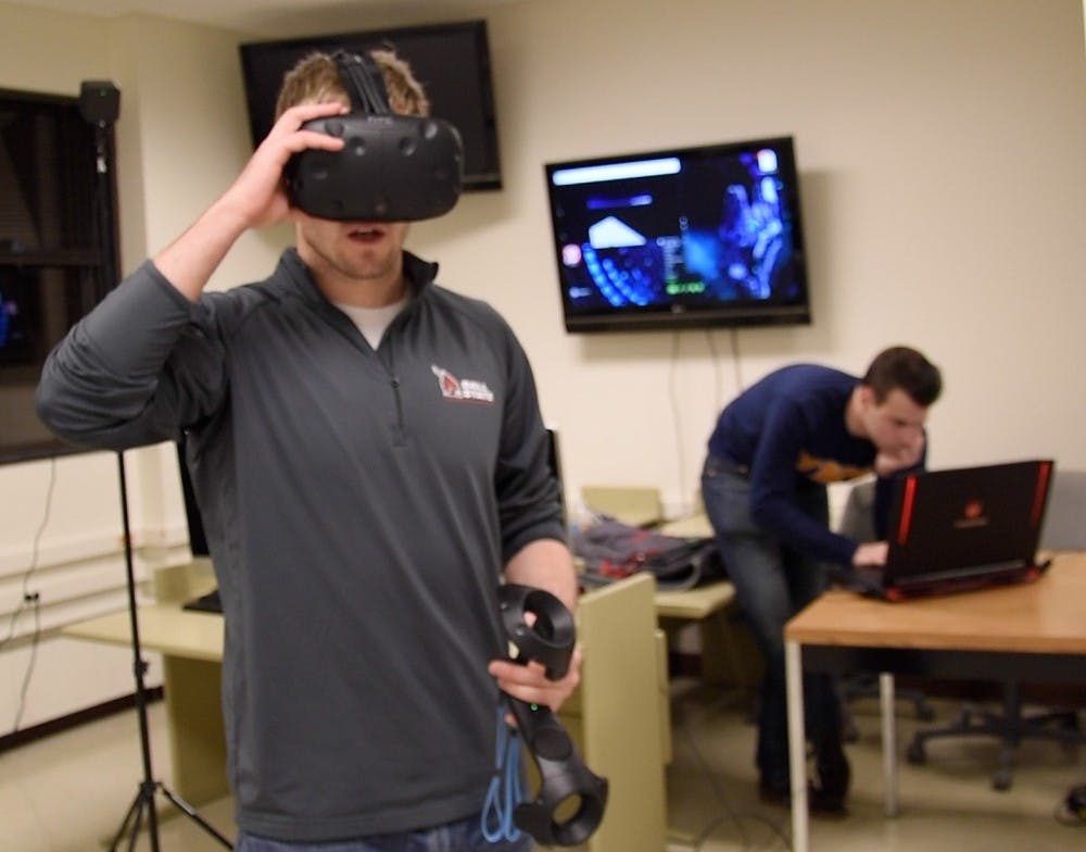 Bradley Ridge, a senior computer science major, adjusts his virtual reality headset before calibrating the controllers. Ridge is working with the computer science program in hopes of doing research with virtual reality and it's role in education. Patrick Calvert // DN