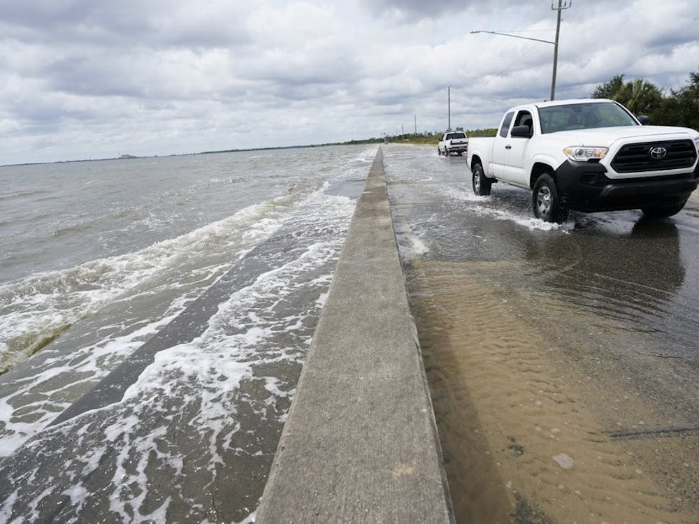 Waters from the Guld of Mexico poor onto a local road, Monday, Sept. 14, 2020, in Waveland, Miss. Hurricane Sally, one of a record-tying five storms churning simultaneously in the Atlantic, closed in on the Gulf Coast on Monday with rapidly strengthening winds of at least 100 mph (161 kph) and the potential for up to 2 feet (0.6 meters) of rain that could bring severe flooding. (AP Photo/Gerald Herbrt)