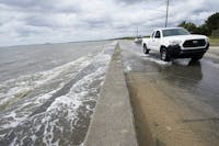 Waters from the Guld of Mexico poor onto a local road, Monday, Sept. 14, 2020, in Waveland, Miss. Hurricane Sally, one of a record-tying five storms churning simultaneously in the Atlantic, closed in on the Gulf Coast on Monday with rapidly strengthening winds of at least 100 mph (161 kph) and the potential for up to 2 feet (0.6 meters) of rain that could bring severe flooding. (AP Photo/Gerald Herbrt)