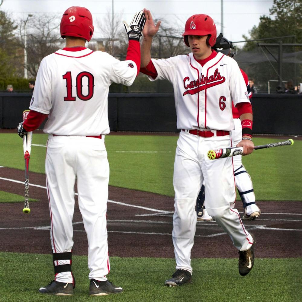 Ball State’s junior infielder Sean Kennedy congratulates junior infielder Alex Maloney on making it back to home base during the game against Dayton on March 18. DN PHOTO GRACE RAMEY