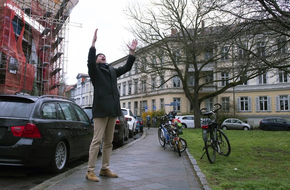 Silvius von Kessel, cathedral organist, choirmaster and composer, conducts residents playing and singing 'By loving forces silently surrounded...' by Dietrich Bonhoeffer on their balconies and windows March 29, 2020, in Erfurt, central Germany, Sunday. (AP Photo/Jens Meyer)