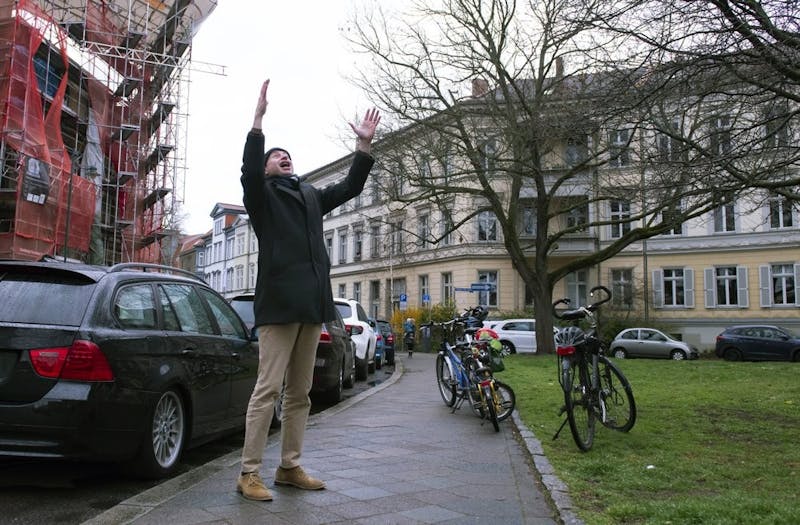 Silvius von Kessel, cathedral organist, choirmaster and composer, conducts residents playing and singing 'By loving forces silently surrounded...' by Dietrich Bonhoeffer on their balconies and windows March 29, 2020, in Erfurt, central Germany, Sunday. (AP Photo/Jens Meyer)