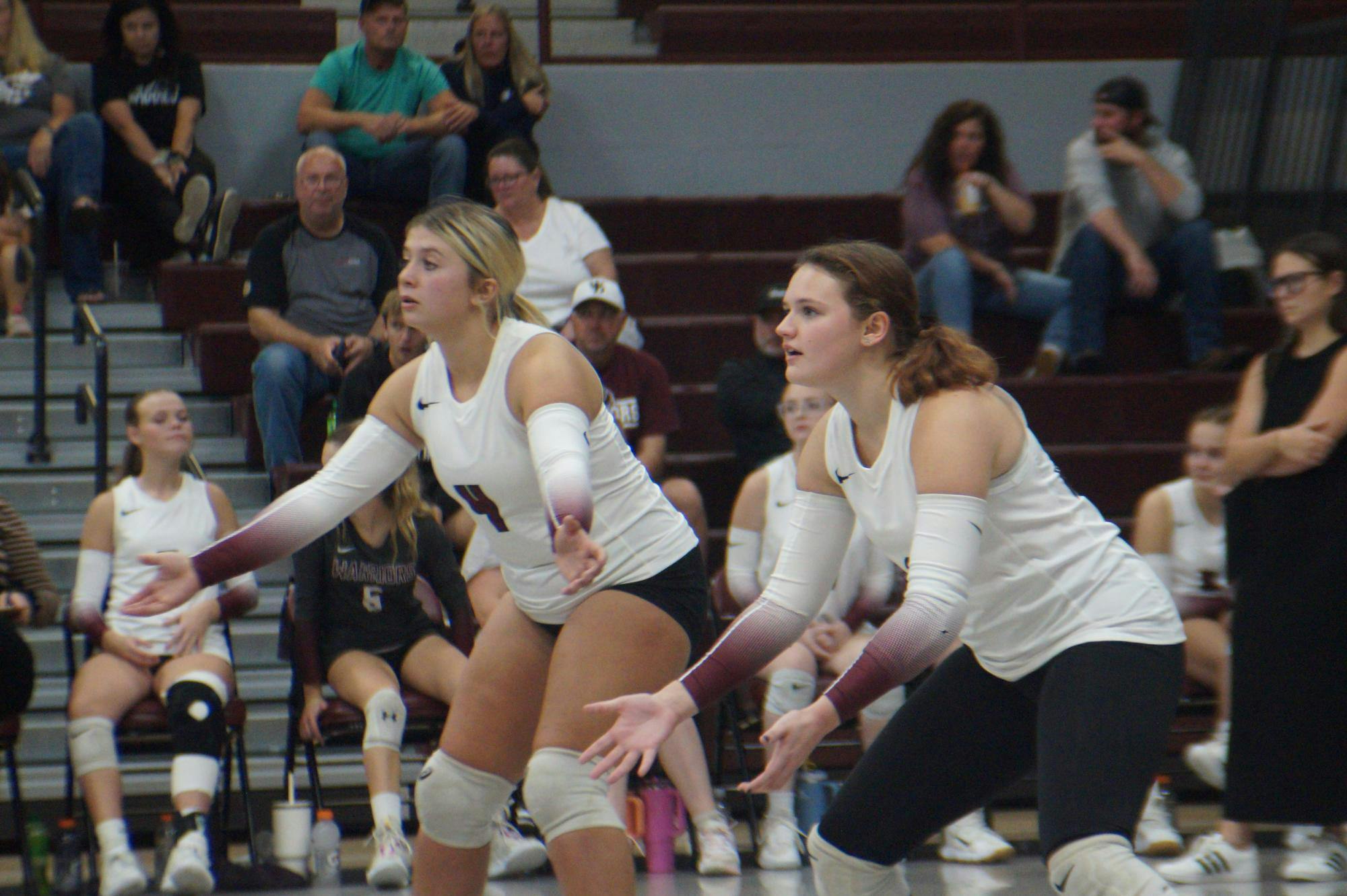 Seniors Ansley Draper, 4, and KyLynn New, 1, prepare to receive a serve from the Eagles. Both seniors will play in the upcoming match against the Southern Wells Raiders. PHOTO BY NICK ROARK
