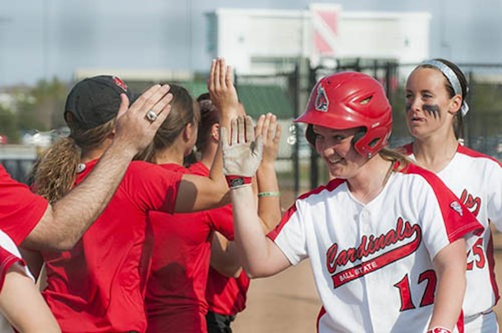 Junior Lauren Schroeder receives high-fives from her team after her grand slam ended the game against Butler. DN PHOTO JONATHAN MIKSANEK