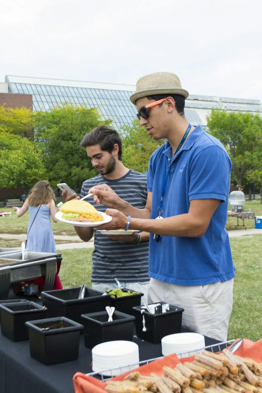 Junior Cruz Aleman, a dietitics and Spanish double major, fills up his plate on Sept. 18 at the Fiesta on Green on the University Green. DN PHOTO STEPHANIE AMADOR