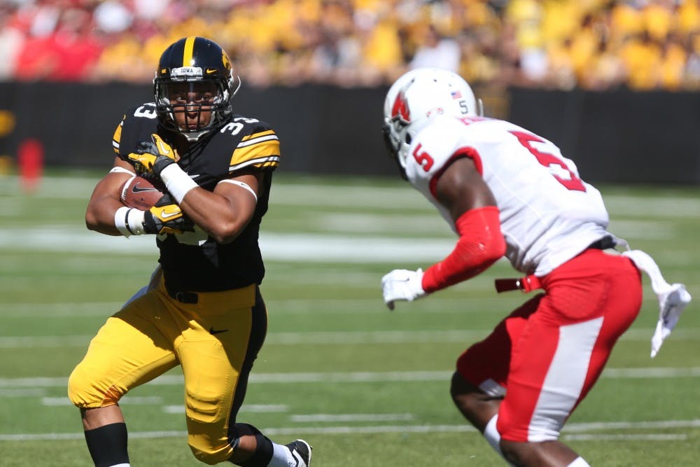 Iowa running back Jordan Canzeri watches Ball State cornerback Eric Patterson as he makes his way down field on Sept. 6 in Kinnick Stadium. Canzeri carried the ball five times for 27 yards on the game. Iowa defeated Ball State, 17-13. (The Daily Iowan/Tessa Hursh)