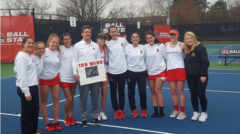 The Ball State Women's Tennis team poses with head coach Max Norris after he picks up his 100th win against Buffalo on April 5, 2019 at Cardinal Creek. Ball State swept the Bulls 7-0. Evan Weaver, DN