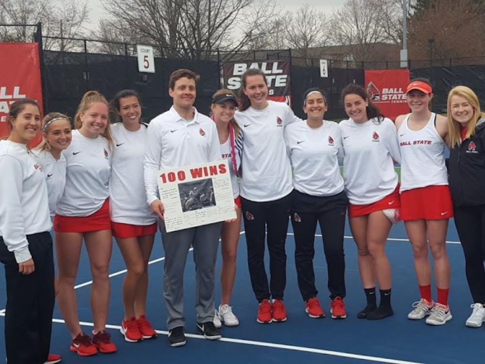 The Ball State Women's Tennis team poses with head coach Max Norris after he picks up his 100th win against Buffalo on April 5, 2019 at Cardinal Creek. Ball State swept the Bulls 7-0. Evan Weaver, DN