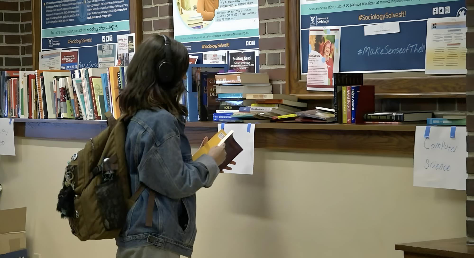 A student peruses books at the BIG Booksale in the North Quad.