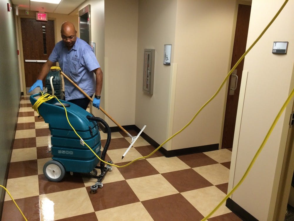 <p><strong>Daniel Henderson</strong>, a Ball State custodian, cleans water off the floor of the North Quad basement. Heavy rainfall caused the building's drainage systems to back up leading to standing water. </p>