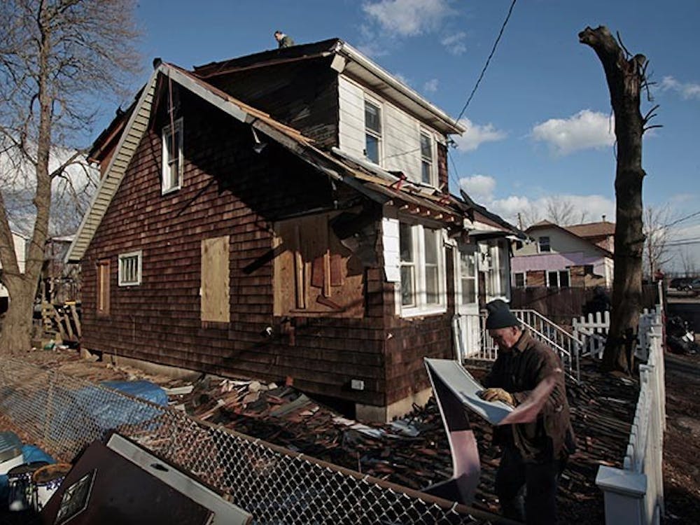 Peter Gill, on the roof of his house in New Dorp Beach, New York, gets help from family and friends to fix his house despite the fact that he has not received insurance money after Superstorm Sandy. (Carolyn Cole/Los Angeles Times/MCT)