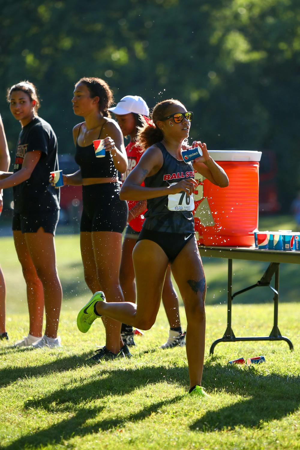 Junior Jessica Velez runs through the water station during her 5k at the We Fly Ball State Invitational Sept. 1. Velez finished fourth with a 19:30.0 time. Daniel Kehn, DN