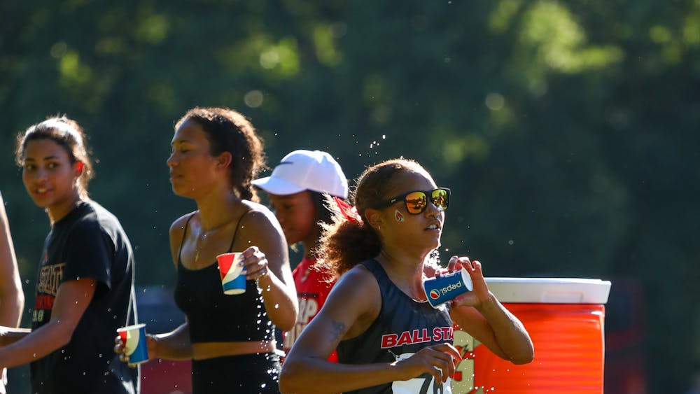 Junior Jessica Velez runs through the water station during her 5k at the We Fly Ball State Invitational Sept. 1. Velez finished fourth with a 19:30.0 time. Daniel Kehn, DN