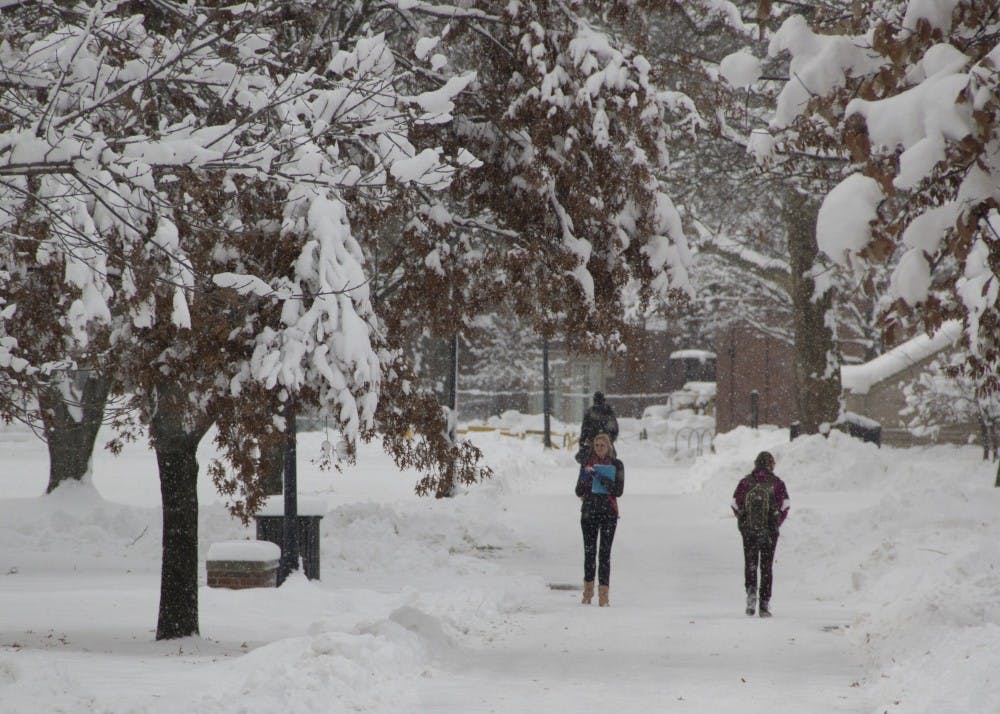 Bethany Cole and other students walk to class in the Quad on the first day of the semester. Campus came to life Jan. 8 morning after extreme cold and snow canceled the first two days of the semester. Crews are still working to clear the sidewalks after Muncie received about foot of snow Jan. 5, according to the National Weather Service. 