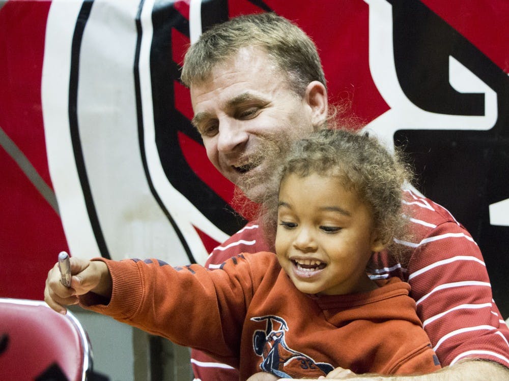 Men's basketball head coach James Whitford helps his son Spencer Whitford sign autographs at Ball State's Basketball Fan Jam 2013 on Oct. 28 at Worthen Arena. DN PHOTO TAYLOR IRBY