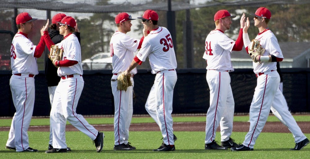 Ball State’s baseball team congratulates each other after winning the first game of a double-header against Dayton on March 18. DN PHOTO GRACE RAMEY