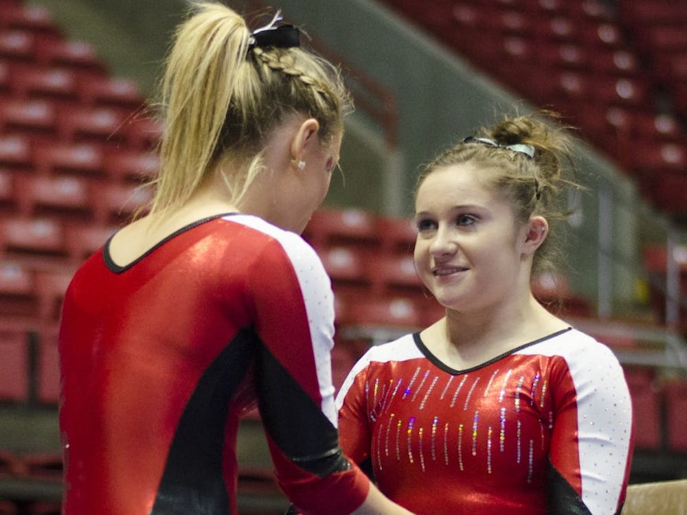 Junior Sarah Ebeyer talks to freshman Kaitlyn Menzione before Menzione perfumed on the beam during the meet against Townson on Jan. 17 at Worthen Arena. DN PHOTO BREANNA DAUGHERTY