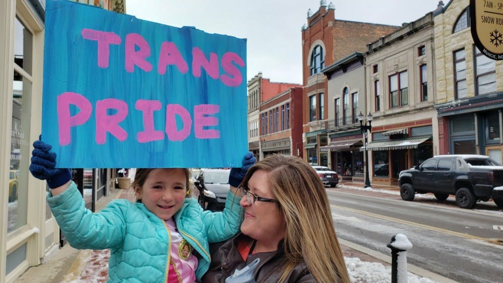 <p>Hazel and her mother, Felicia Lewis, hold up a sign March 31 at the Transgender Day of Visibility event in downtown Muncie. The event was organized by East Central Indiana Trans Alliance. <strong>John Lynch, DN</strong></p>