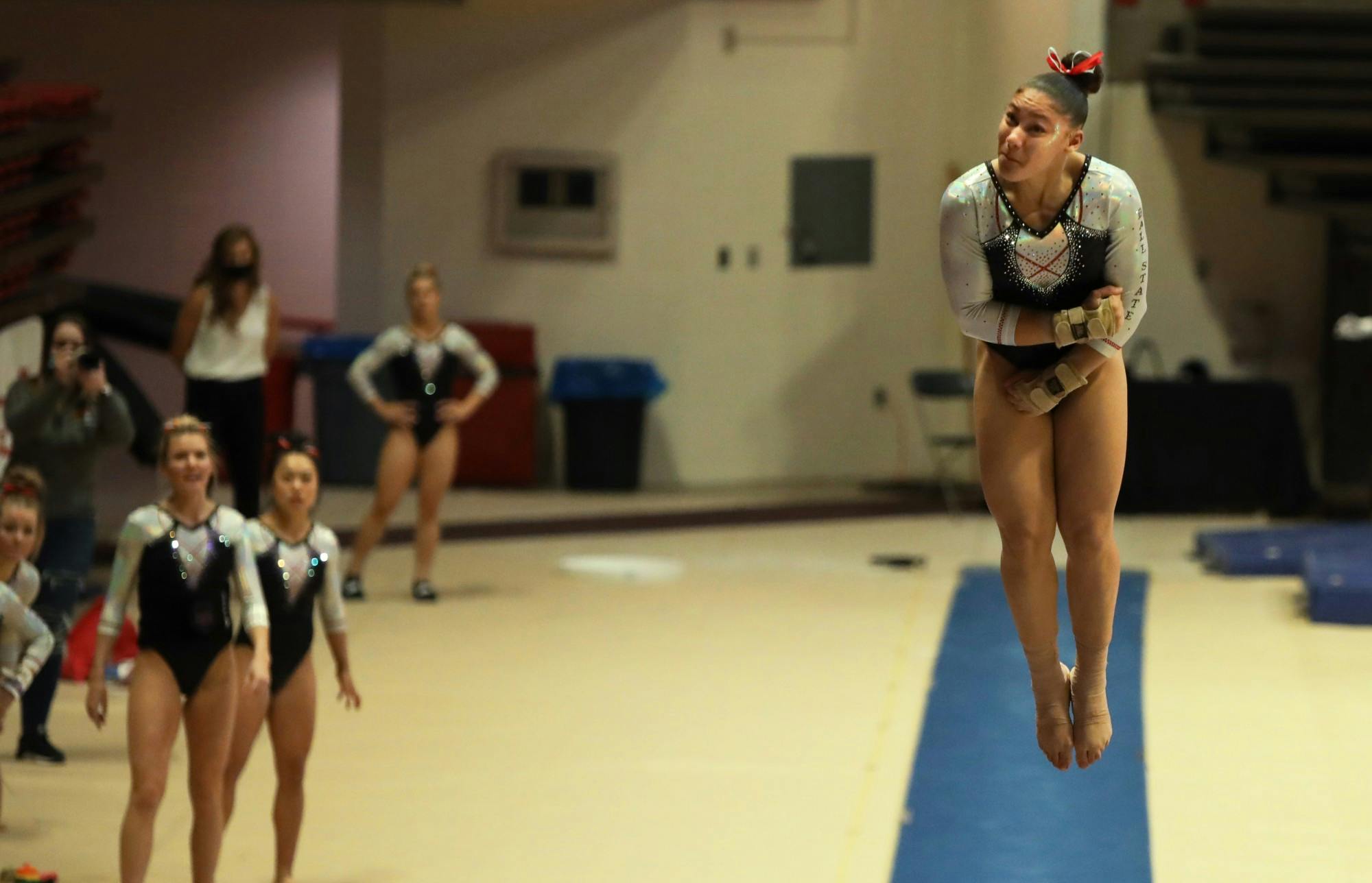 Sophomore Victoria Henry performs her vault routine as her teammates watch Jan. 23 at Worthen Arena. The Cardinals lost to Kent State 194.800-194.875. Rylan Capper, DN 