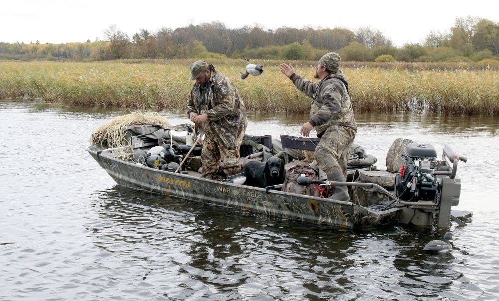 Casey Sunsdahl, right, of Soudan tosses a decoy to the front of his duck boat after a morning of hunting on Lake of the Woods. His hunting partner is Brad Redmond of Virginia. (Sam Cook/Duluth News Tribune/TNS)