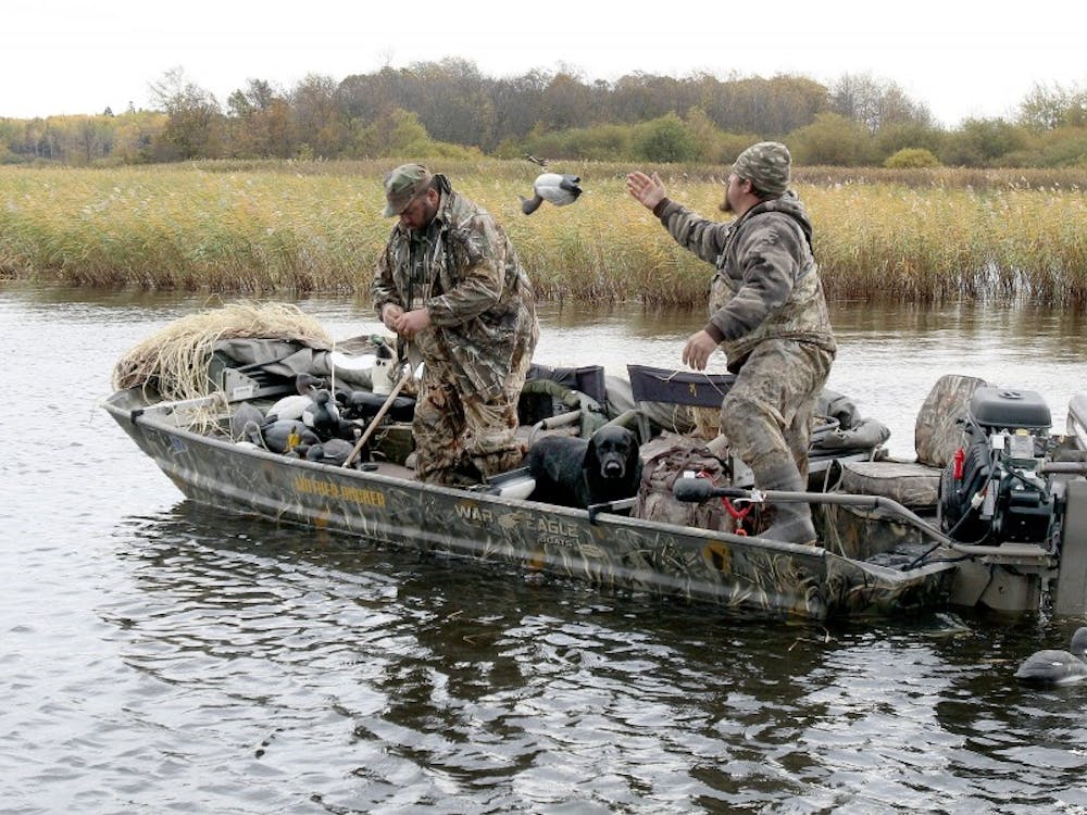 Casey Sunsdahl, right, of Soudan tosses a decoy to the front of his duck boat after a morning of hunting on Lake of the Woods. His hunting partner is Brad Redmond of Virginia. (Sam Cook/Duluth News Tribune/TNS)