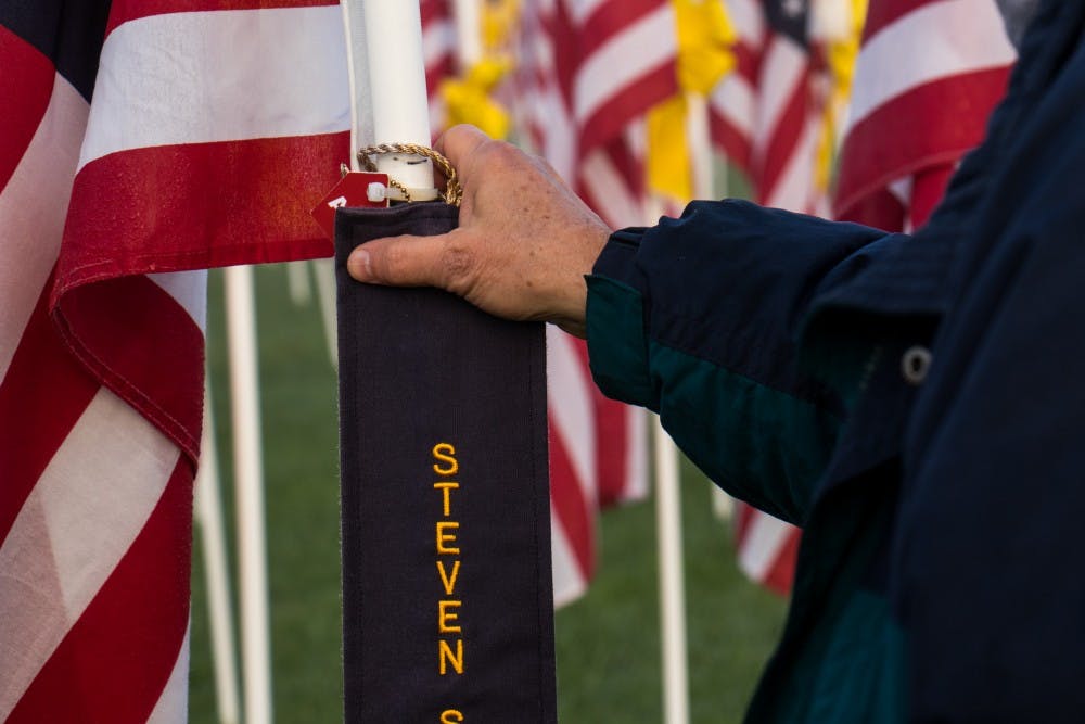 <p>At Minnetrista's Flags of Honor Dave McGalliard stops to look at a flag Tuesday, Sept. 11, 2018, in honor of a former student of his and a firefighter who passed away. Black ribbons on Flags represent lives that have been lost in the line of duty. <strong>Eric Pritchett, DN</strong></p>