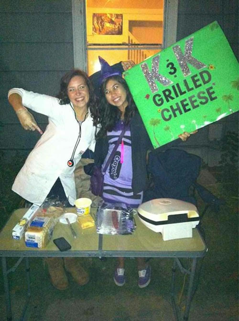 Katie Simmons and Kayla Hernandez of K&K Grilled Cheese pose beside their grilled cheese stand. The two have raised around $800 to put toward a volunteer trip to Nicaragua. PHOTO PROVIDED BY KATIE SIMMONS
