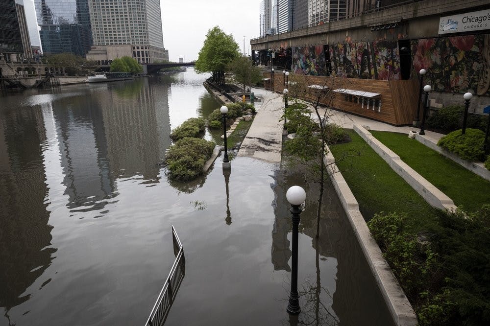 <p>The Chicago River overflowed its banks and flooded the Riverwalk after overnight showers and thunderstorms across the city May 18, 2020 in Chicago.<strong> (Ashlee Rezin Garcia/Chicago Sun-Times via AP)</strong></p>