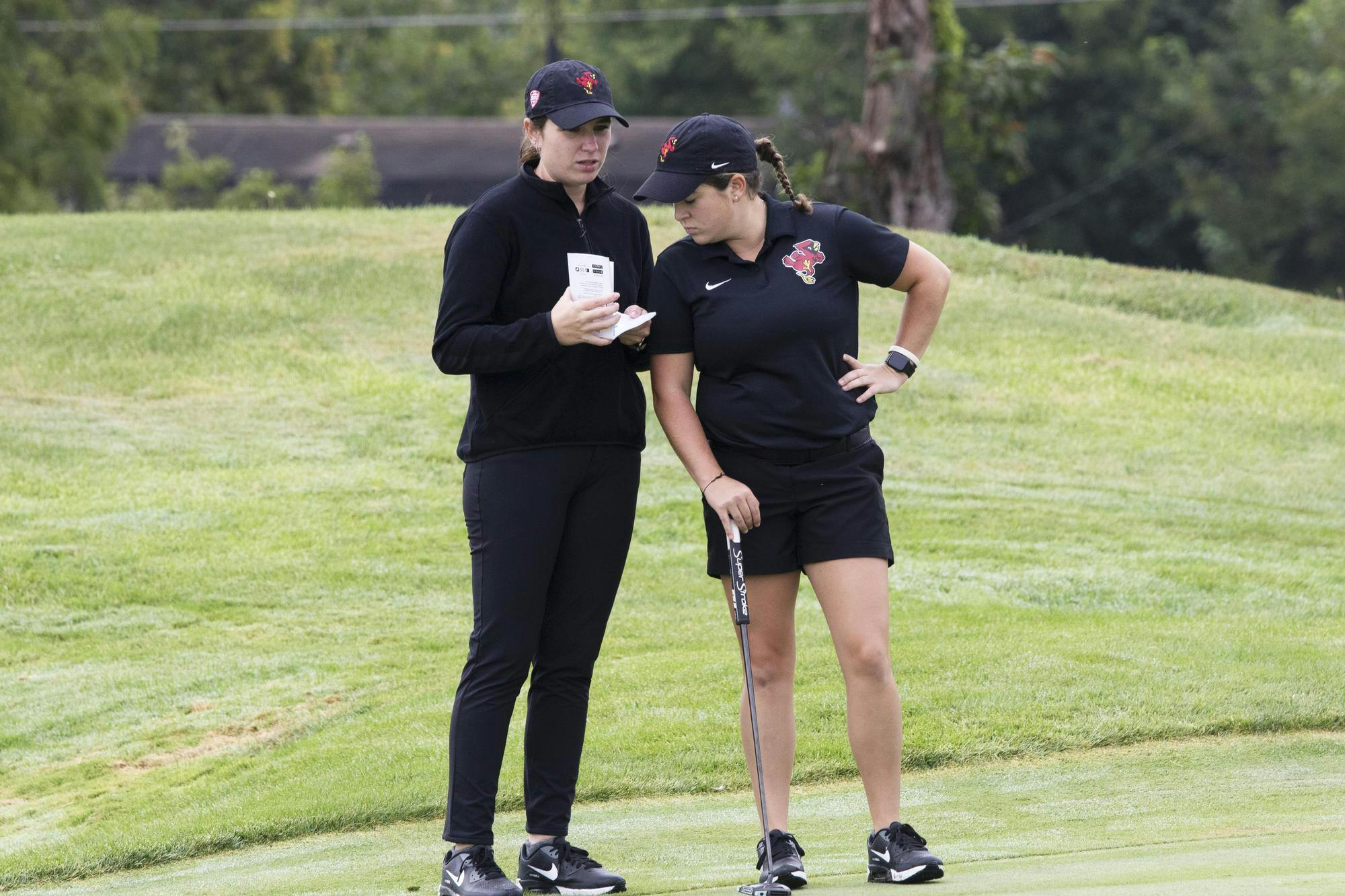 Senior Kiah Parrott studies her putt with graduate assistant Valeria Patino Sep. 18 during the Brittany Kelly Classic at The Players Club. Zach Carter, DN.