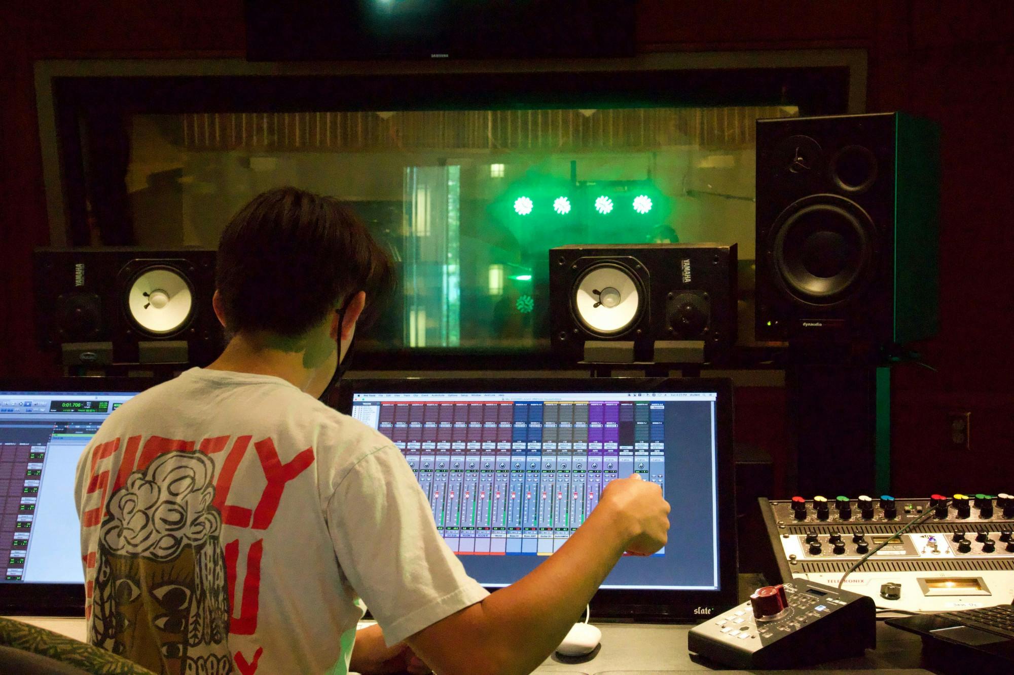 Senior music production major and Cardinal Music Group executive producer Adam Fonacier listens while Pressed in Black records Sept. 12, 2020, in the Music Instruction Building. Fonacier said the band recorded all eight of the songs on their upcoming album. John Lynch, DN