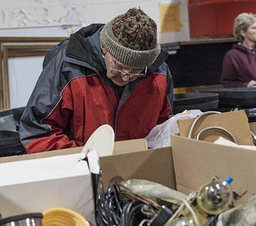 A community member sorts through a box of machine parts during the auction in downtown Muncie on Feb. 16. The auction had a collection of items provided by Ball State, including furniture and electronics. DN PHOTO JONATHAN MIKSANEK