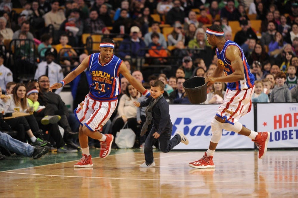 <p>Brawley Chirshom, left, and a teammate chase an audience member around the court during a performance in Seattle. <strong>Harlem Globetrotters, Photo Provided</strong></p>