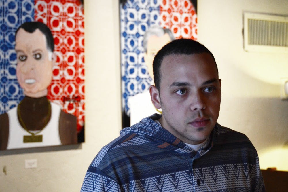 <p><strong>Anthony Friday</strong> discusses his artwork in The Cup. One of Friday's paintings depicting a pigeon and the n-word caused controversy when a person was offended by the piece. <em>DN PHOTO CHRISTOPHER STEPHENS</em></p>