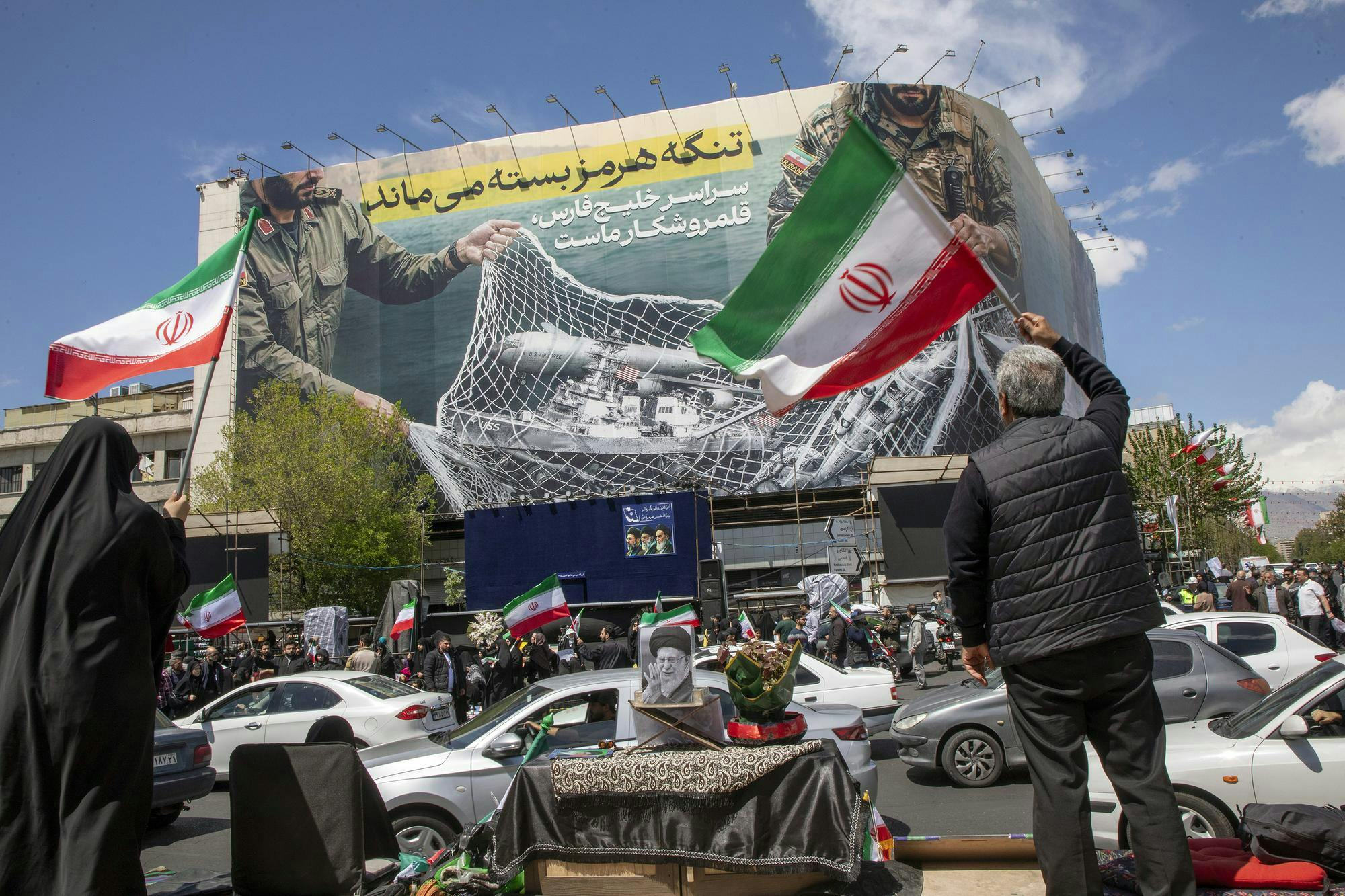 TEHRAN, IRAN - APRIL 8: Iranians hold national flags as they gather in Tehran's Revolution Square after the United States and Iran agreed to a two-week ceasefire, on April 8, 2026 in Tehran, Iran. The United States and Iran agreed to a two-week ceasefire barely an hour before the US president's April 8 deadline to obliterate the country, triggering global relief alongside apprehension. (Photo by Majid Saeedi/Getty Images)