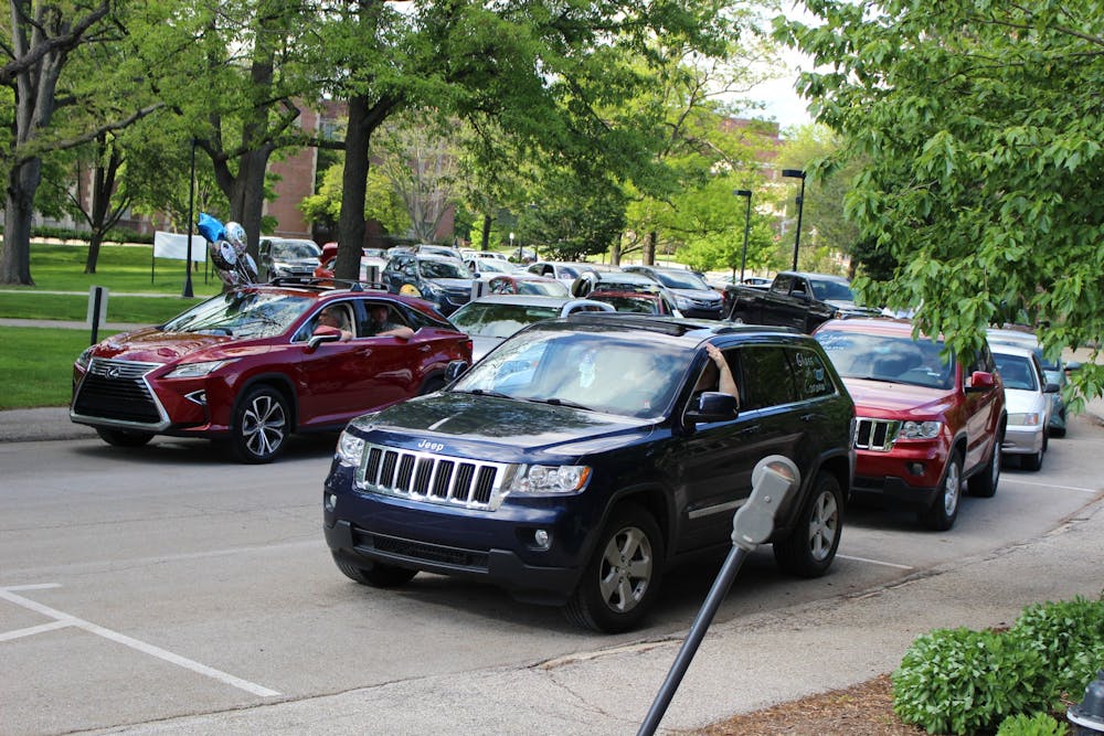 <p>Vehicles form two lines for the Burris Laboratory School drive-by graduation May 22, 2020, on Campus Drive at Ball State. According to Dawn Miller, principal, more than 200 cars appeared to congratulate seniors. The line stretched from behind the Frank A. Bracken Administration building to the nearby parking garage. <strong>Bailey Cline, DN</strong></p>