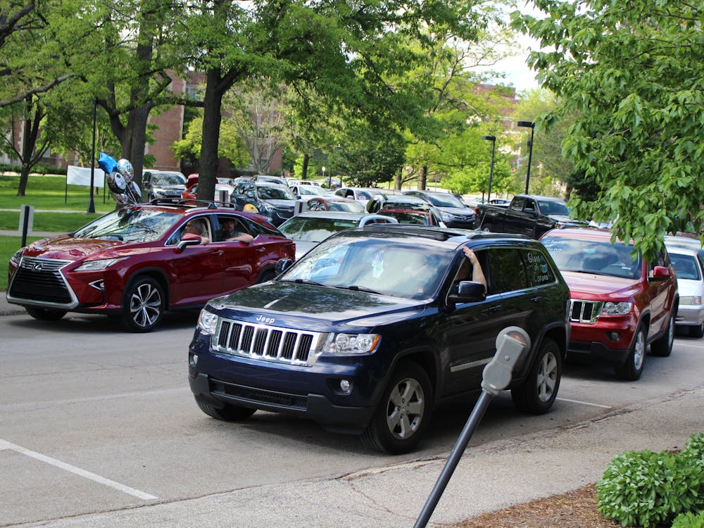 Vehicles form two lines for the Burris Laboratory School drive-by graduation May 22, 2020, on Campus Drive at Ball State. According to Dawn Miller, principal, more than 200 cars appeared to congratulate seniors. The line stretched from behind the Frank A. Bracken Administration building to the nearby parking garage. Bailey Cline, DN