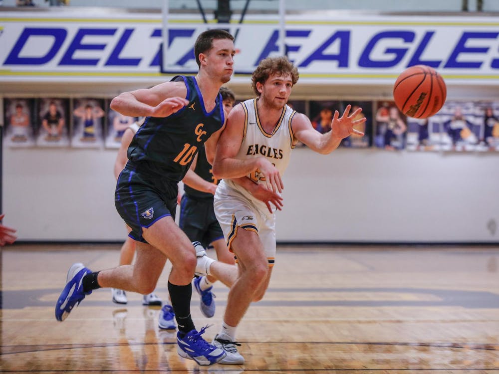 Senior forward Jackson Wors makes a last second pass against Greenfield-Central Feb. 1 at Delta High School. Wors made two three-point shots in the game. Andrew Berger, DN 
