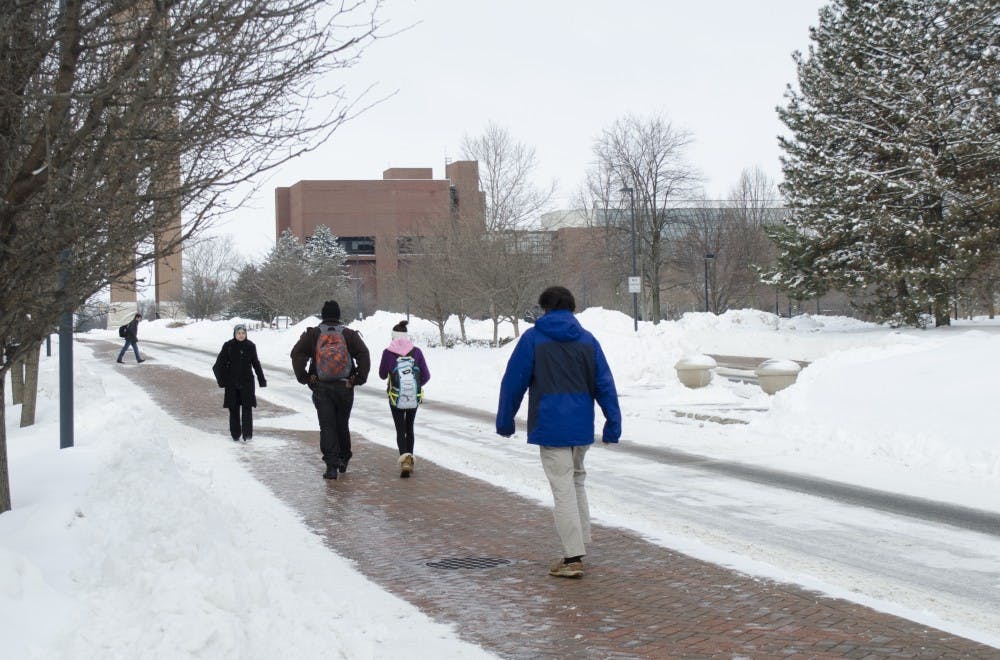 Students walk down the sidewalk on McKinley Avenue on Feb. 5. Classes were canceled until noon Feb. 5 because of the winter storm. DN PHOTO BREANNA DAUGHERTY
