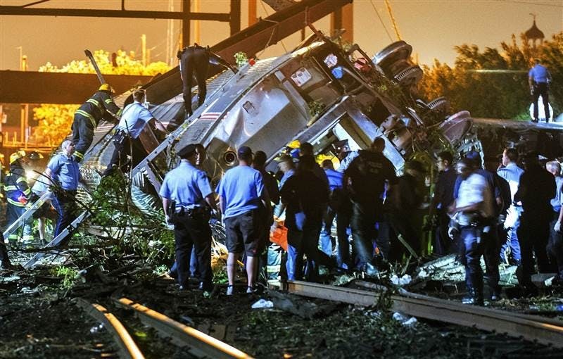 Rescue workers climb the Amtrak train after it derailed in Philadelphia, Pennsylvania on Tuesday. The crash killed at least seven passengers and injured more than 200 others. Photo provided by Bryan Woolston, Reuters.