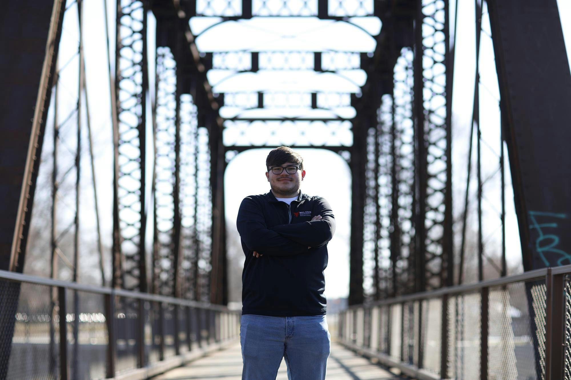 Senior landscape architecture major Noah Keinath poses in front of one of many repurposed railroad bridges along the Cardinal Greenway Feb. 20 in Muncie. The Cardinal Greenway is the longest regional rail trail in Indiana. Andrew Berger, DN&nbsp;