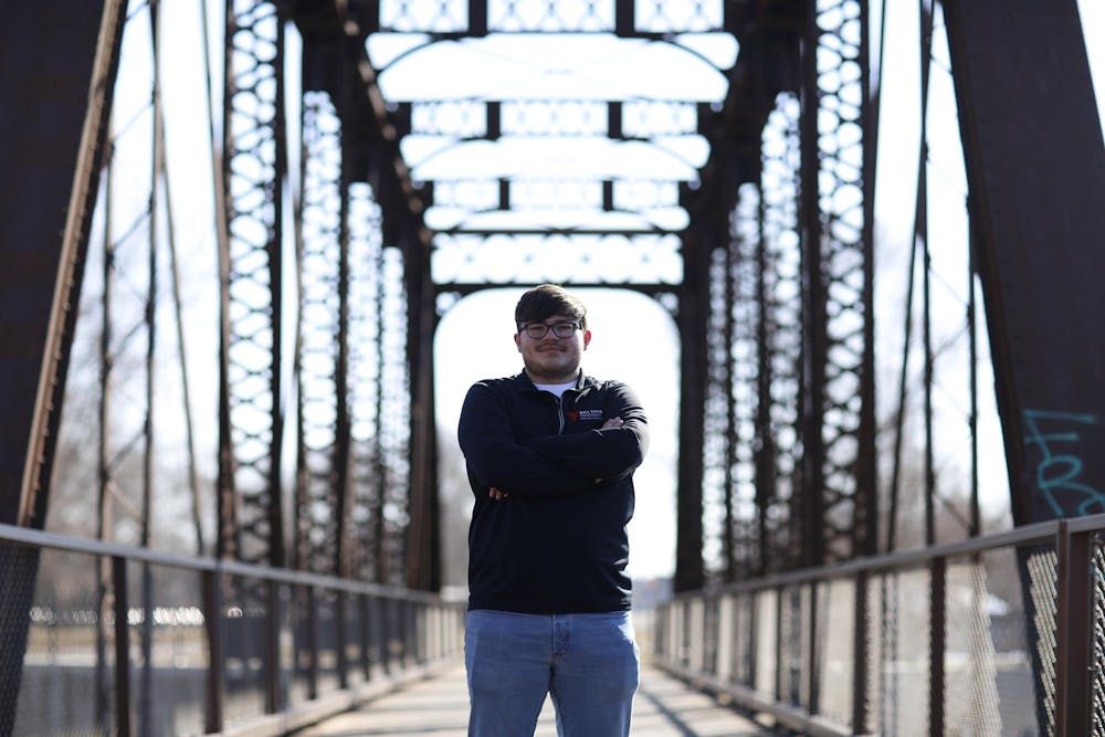 <p>Senior landscape architecture major Noah Keinath poses in front of one of many repurposed railroad bridges along the Cardinal Greenway Feb. 20 in Muncie. The Cardinal Greenway is the longest regional rail trail in Indiana. Andrew Berger, DN&nbsp;</p>