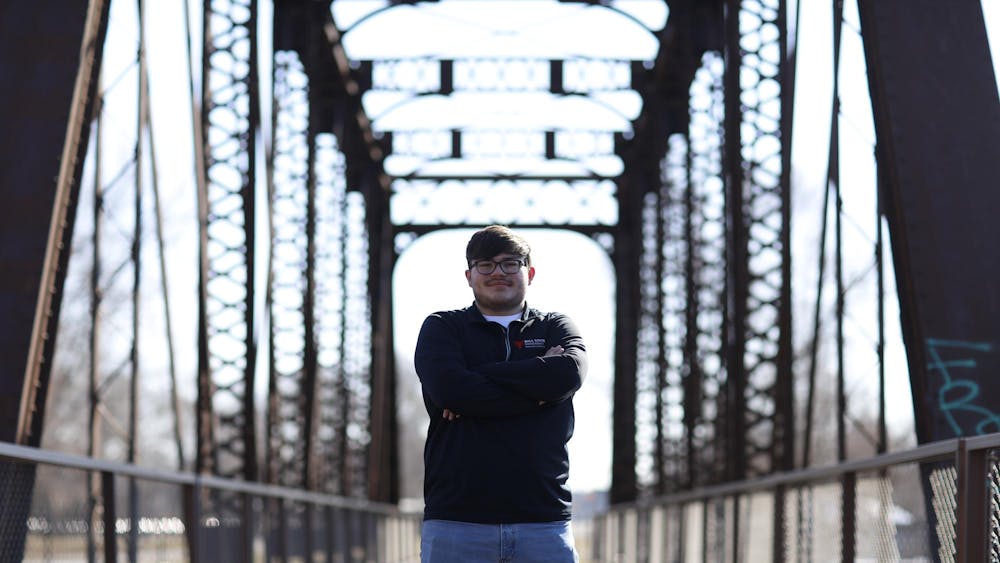 Senior landscape architecture major Noah Keinath poses in front of one of many repurposed railroad bridges along the Cardinal Greenway Feb. 20 in Muncie. The Cardinal Greenway is the longest regional rail trail in Indiana. Andrew Berger, DN&nbsp;